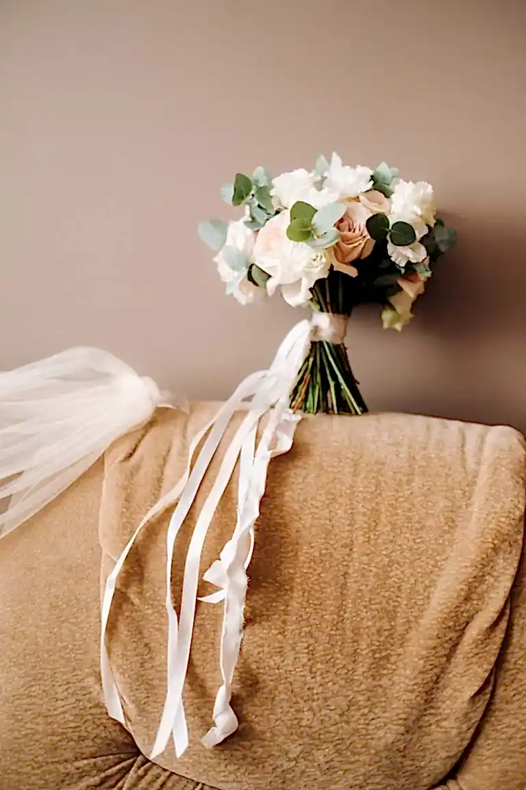 wedding bouquet with roses on a chair and boutonni 2MFPZ5K